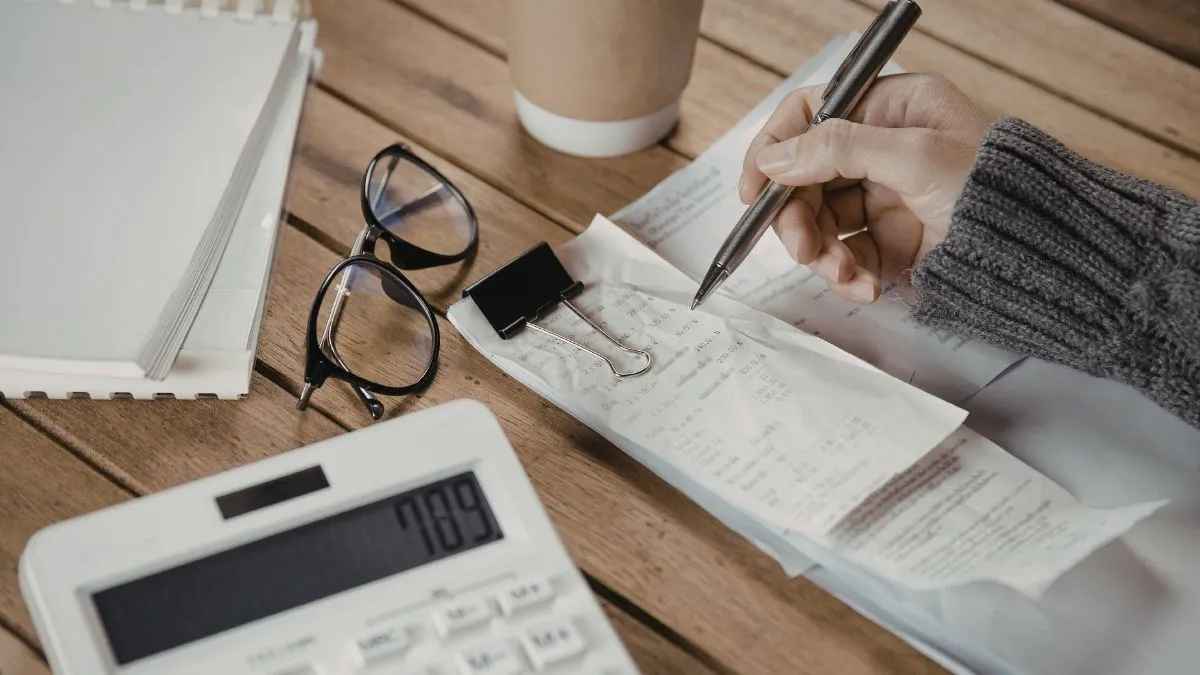 Como organizar seu dinheiro do zero - Uma pessoa fazendo contas em bloco de anotações